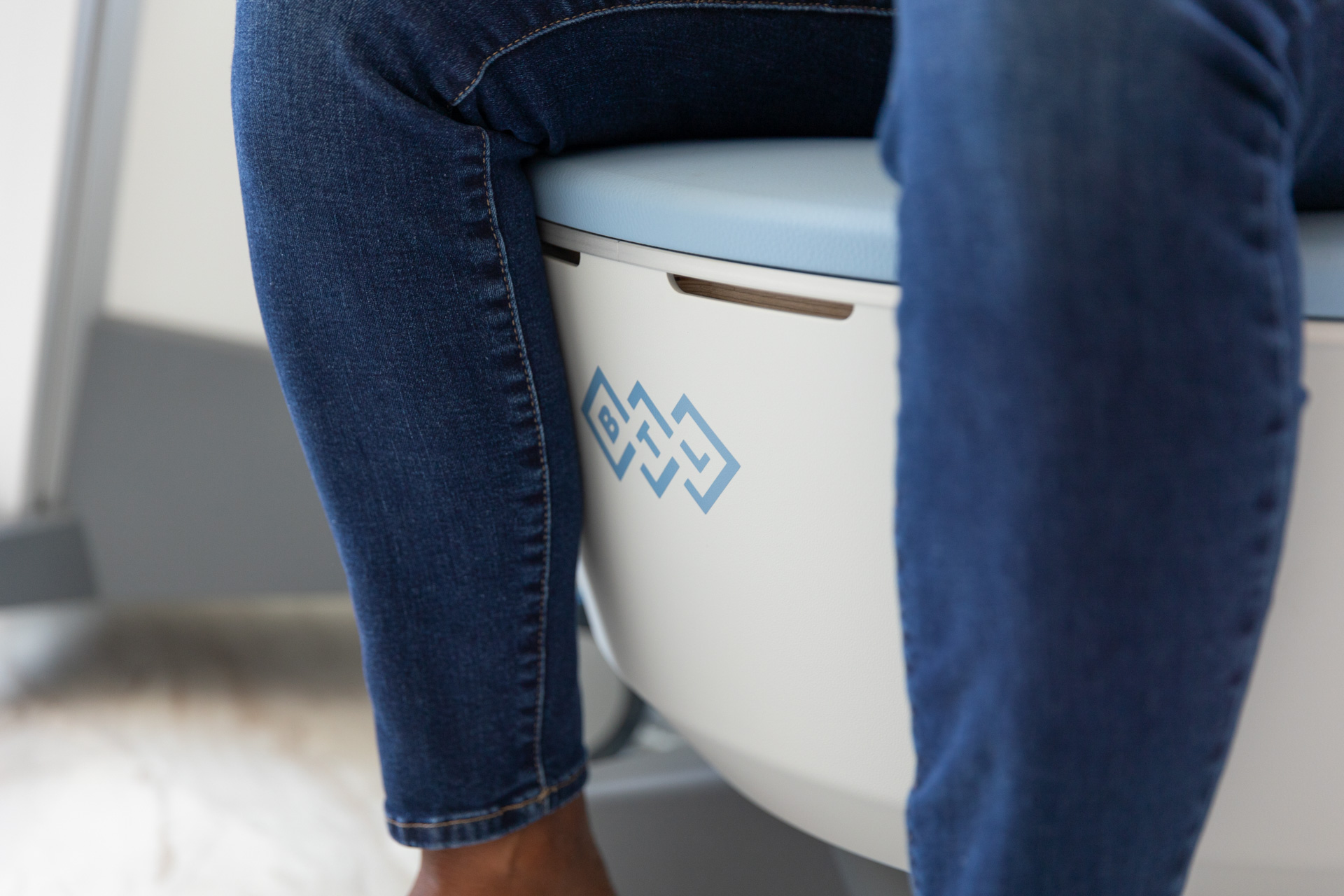 A close-up of a patient sitting on the Emsella chair for urinary incontinence treatment in Wellen Park.