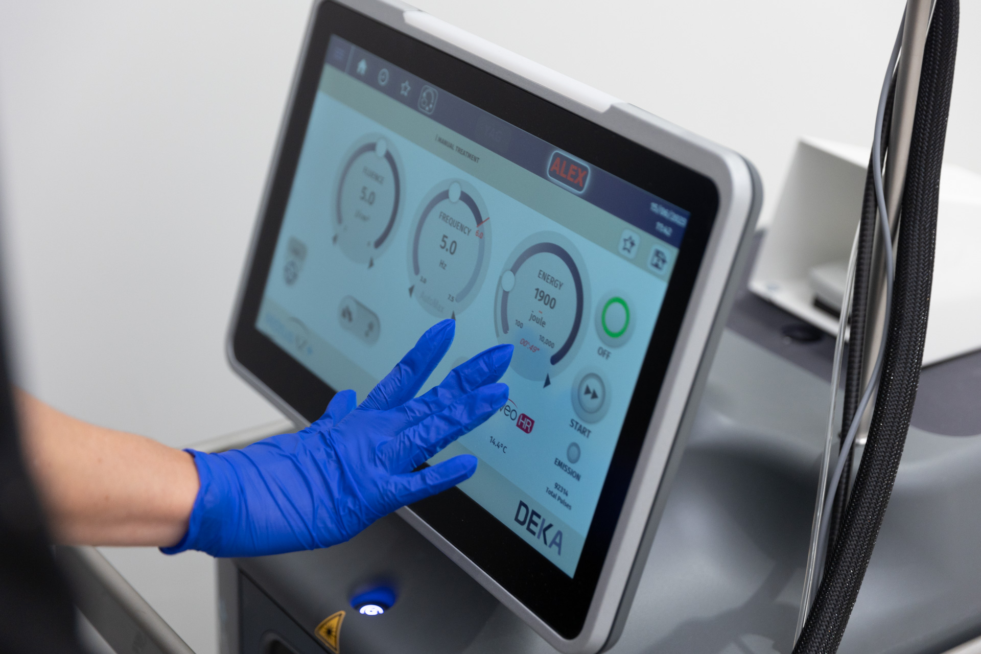  A provider's gloved hands make a setting selection on the Motus AY device's screen to provide laser hair removal near Sarasota.