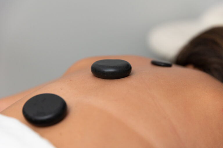 A close-up shot of heated stones being applied during a massage as one of the spa services in North Port, FL