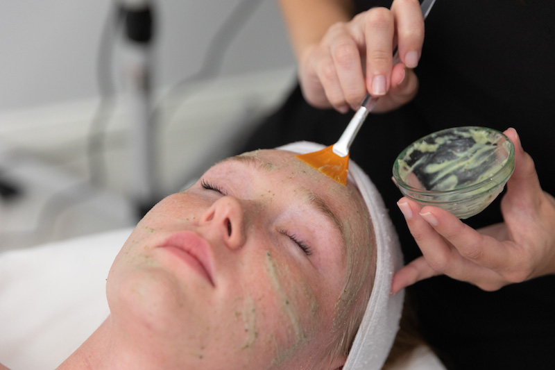 A young woman with a brush to her forehead undergoing facials near Port Charlotte, FL