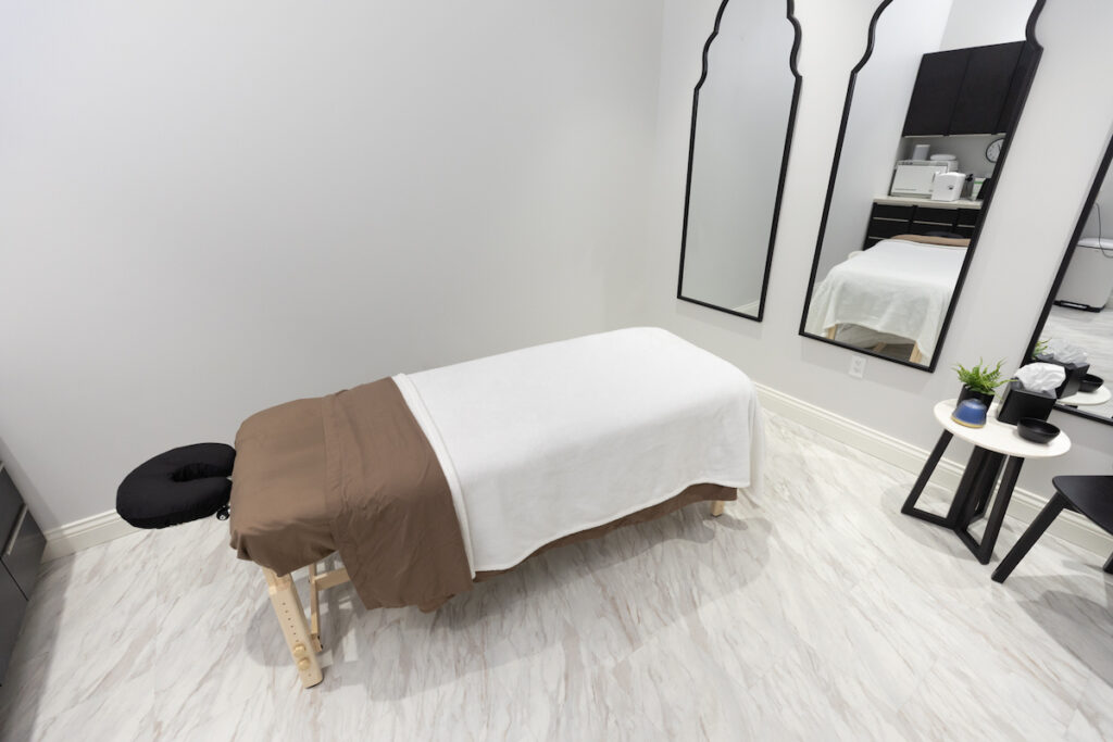 Massage table in sleek white and black room ready for massages in North Port, FL