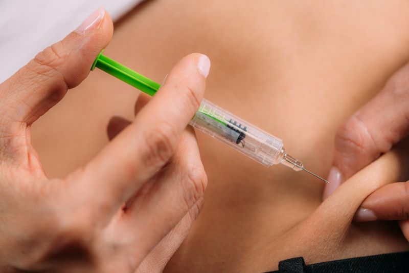 A woman's hands holding a hypodermic as she prepares to administer Weight Loss Injections in Englewood, FL