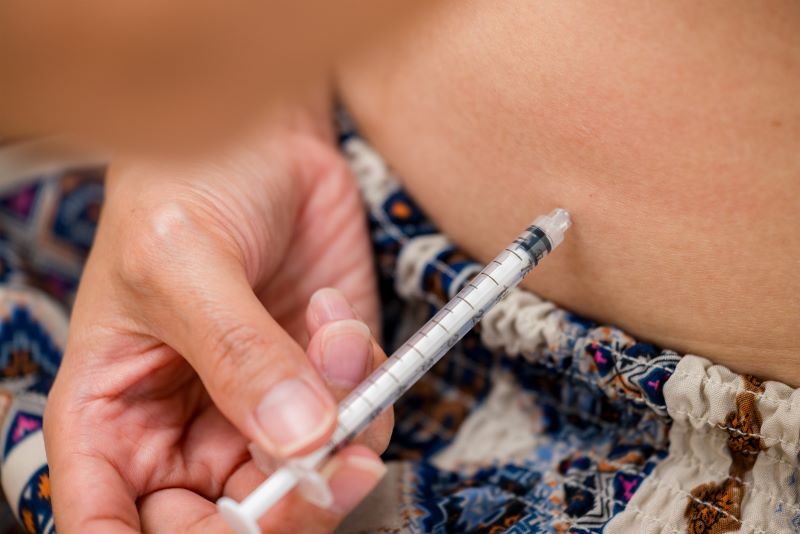 Closeup shot of a hand holding a hypodermic injecting into a belly a treatment of Semaglutide in North Port, FL